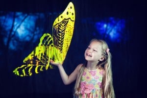 Kind spielt mit einem Schmetterling-Hologramm