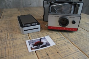 Der SnapJet neben einer alten Polaroid-Kamera